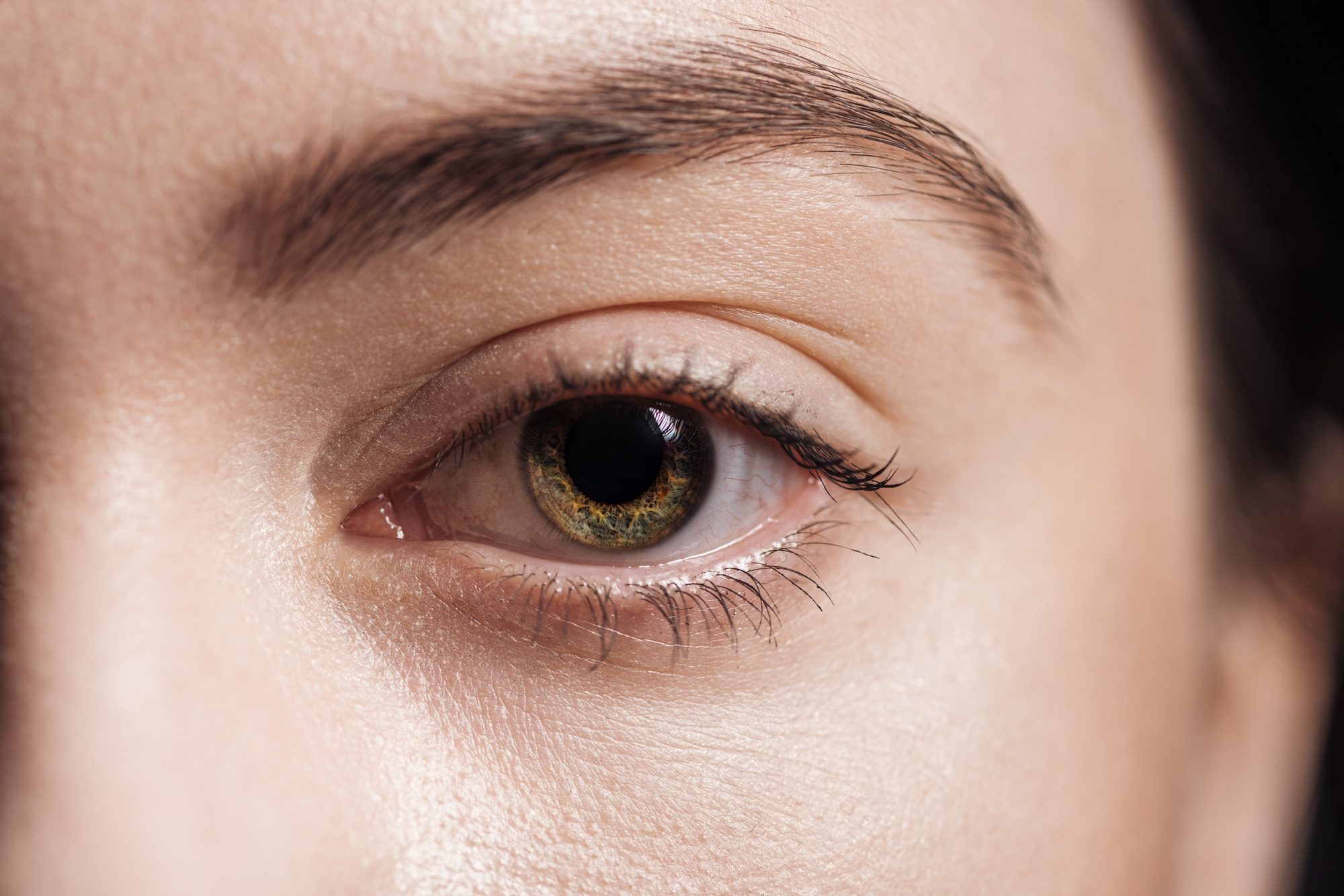 close up view of young woman green eye looking at camera